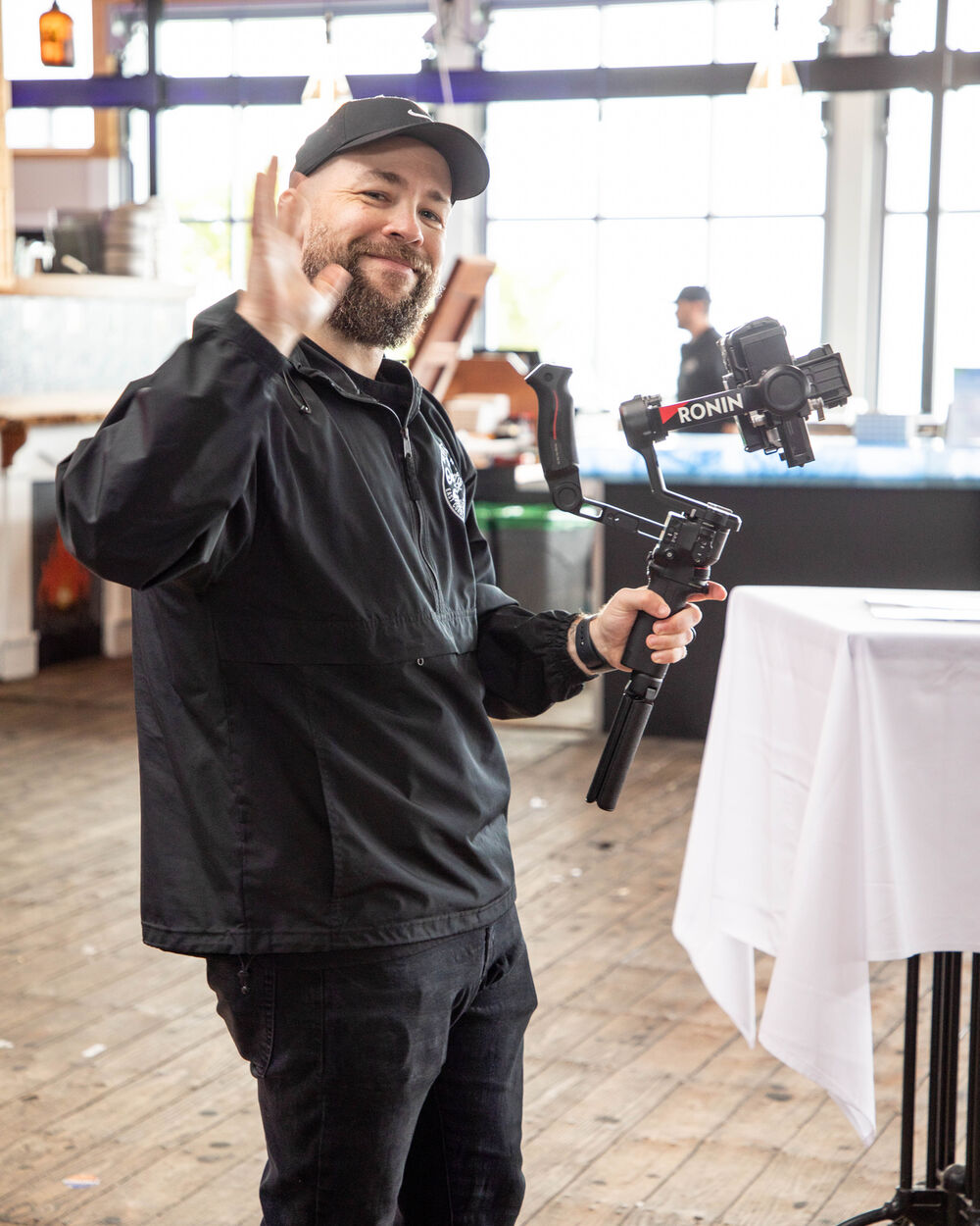 James Lanham waving on set with a camera on a gimbal